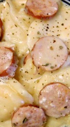 a plate filled with cheese and sausage covered in gravy on top of a table