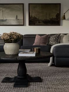 a living room filled with furniture and pictures on the wall above it's coffee table