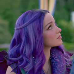 a woman with purple hair is looking off into the distance