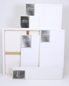 three white boxes with black and silver labels on them