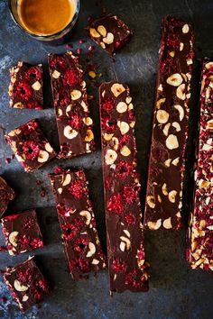 chocolate barkle with nuts and cranberries next to a cup of tea