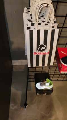 a pair of sneakers and a bag hanging from a wire rack in a shoe store