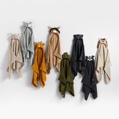 five towels hanging on the wall in different colors and sizes, each with an animal's head sticking out of it