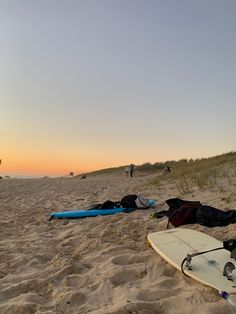 two surfboards laying in the sand on a beach