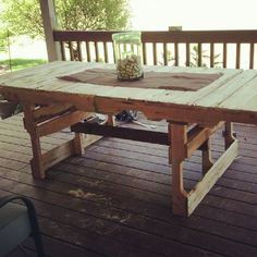 a wooden table sitting on top of a wooden deck