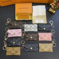 louis vuitton wallets and keychains are on display in front of an orange box