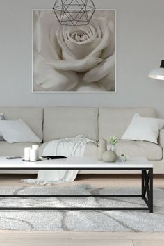 a living room with a white couch and coffee table in front of a painting on the wall