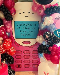 there is a cell phone surrounded by balloons and other items in the shape of a cartoon character