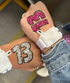 two girls with tattoos on their arms and one has the number thirteen painted on her arm