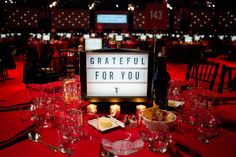 a table set up for a formal function with wine glasses, plates and utensils