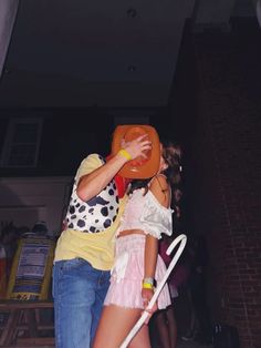 a man and woman are dancing on the dancefloor with an orange frisbee