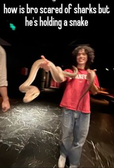 a young boy is holding a snake in front of two other people and the caption reads, how is bro scared of sharks but he's holding a snake