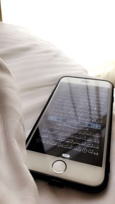 an iphone sitting on top of a white bed