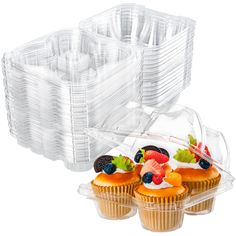 three cupcakes in plastic cases with fruit on top