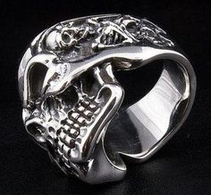 "Grandiose and imposing, make every outfit stand out with this gigantic sterling silver skull biker ring! With it's bold, menacing skull featuring a further two detailed skeletons on the side of the ring and its heavy 39 gram weight, this large, sterling silver ring is sure to grab attention. Produced with the utmost care at every stage and from the finest 100% solid sterling silver, you can be certain you're getting the very best in quality and a ring with the sturdiness and durability to last Biker Skull Ring For Biker Events, 2 Skeletons, Rocker Rings, Rings Gothic, Skeleton Ring, Mens Ring Designs, Promise Bracelet, Skull Rings, Mens Stainless Steel Rings