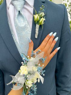 a close up of a person wearing a suit and tie with flowers on his lapel