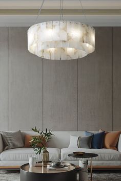 a living room with a couch, coffee table and chandelier hanging from the ceiling