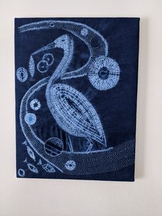 a blue towel hanging on the side of a white wall with an image of a bird