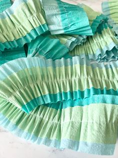 green and blue tissue paper on top of each other in the shape of wavy strips