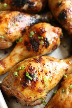 grilled chicken wings with green onions and seasoning in a white baking dish, ready to be eaten