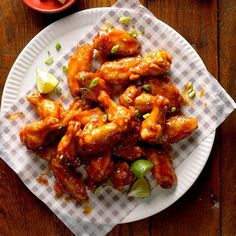 a white plate topped with chicken wings covered in sauce