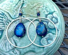 Silver hoop earrings with blue jasper and lapis lazuli stones. I am over the moon about these beauties! They are large and eye-catching but not too heavy! The stones are royal blue jasper.  These earrings are 2 1/2 inches long and 1 1/2 inches wide. The French  earwires are sterling silver.  All my jewelry comes gift boxed with a custom Shelly Mariposa Design butterfly card ready for gift giving, whether it is a gift for you or someone special. Your satisfaction is very important to me. I make e Blue Bohemian Hoop Earrings With Natural Stones, Bohemian Blue Hoop Earrings With Natural Stones, Blue Hoop Jewelry With Natural Stones, Blue Natural Stone Hoop Jewelry, Blue Natural Stone Dangle Hoop Earrings, Blue Hoop Earrings With Natural Stones, Blue Gemstone Hoop Earrings, Blue Teardrop Gemstone Hoop Earrings, Jasper And Lapis