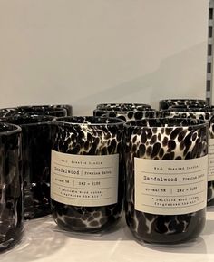 several black and white candles with labels on them