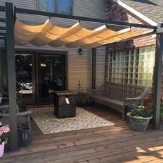 an outdoor patio with wooden decking and hanging awnings