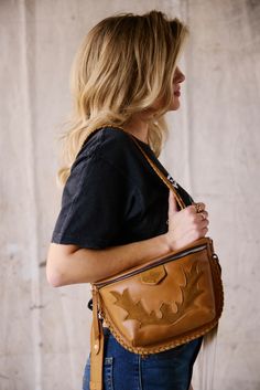 a woman carrying a brown leather purse