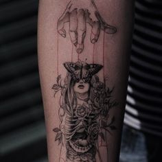 a woman's arm with a tattoo on it that has an image of a demon and flowers