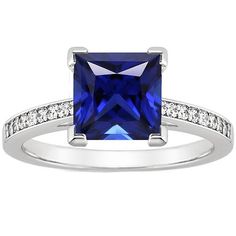 a blue sapphire and diamond ring with diamonds on the sides, set in white gold