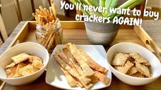 there are three bowls with crackers in them on the table next to a potted plant