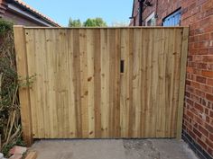 a wooden gate in front of a brick building