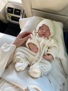 a baby in a car seat being held by someone