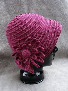 a pink knitted hat with flowers on it