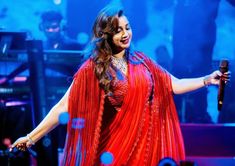 a woman in a red dress holding a microphone