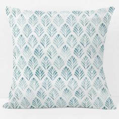 a blue and white pillow with leaves on it