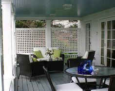 a patio with chairs, table and couches on top of the floor next to each other