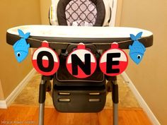 a baby's highchair with the word one on it and fish decorations