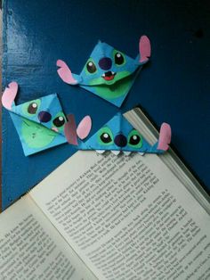 an open book sitting on top of a table next to origami mouses