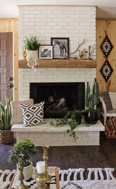 a living room filled with furniture and a fire place in front of a white brick fireplace