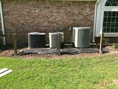 three air conditioners sitting on the side of a house in front of a window