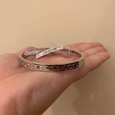 I Purchased The Bracelet And It Is Lovely! It Is Brand New! I Purchased It For $80, It Was Originally Priced At $88. It Has A Clasp That Does Not Allow For The Bracket To Fall Off And Has Beautiful Details On The Side Of The Bracelet. It Is A Beautiful Piece To Add To A Coach Lovers Collection! Coach Bracelets As Gift, Coach Adjustable Bangle, Adjustable Coach Bangle, Coach Round Jewelry For Anniversary, Classic Coach Jewelry For Gifts, Coach Metal Bracelet Jewelry, Coach Metal Bangle Jewelry, Classic Coach Bangle Jewelry, Elegant Coach Bangle Jewelry