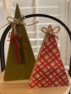 two wooden christmas trees sitting on top of a table