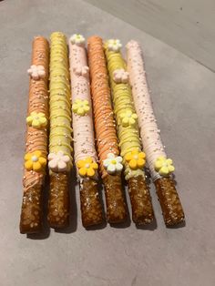 four different types of candy sticks with flowers on them are lined up in a row