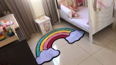 a child's bedroom with a rainbow rug on the floor