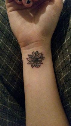 a woman's wrist tattoo with a flower on it