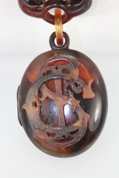 This locket is from the 1890's and it has an initial emblem on the front.  It appears to be S,T,C in script and it is lovely.  There are some scratches on the locket but none that distract from the beauty of this piece. The locket when opened has a glass front for your memories and it is 1 3/4" x 1 1/2" and weights in at 54.0 grams.  The chain is all tortoise links and measures 23" long and it has a fish hook closure all in Tortoise shell. Tortoise shell is endangered so anything before the 1973 is salesable but after 1973 it is prohibited.  This took place in 1973 because the Hawksbill Turtle was almost to extinction and in order to save them this ban went into place. Bronze Antique Finish Locket Necklace In Brass, Antique Bronze Vintage Locket Necklace, Vintage Bronze Locket Necklace In Brass, Cheap Tortoise-colored Jewelry Gift, Hawksbill Turtle, Shell Locket, Tortoise Shell Buttons, North Hollywood, Fish Hook