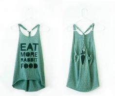 two tank tops hanging up against a wall with the words eat more rabbit food on them