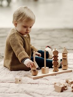 a toddler playing with wooden toys on the floor